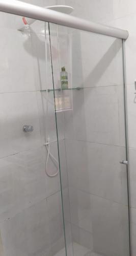 een douche met een glazen deur in de badkamer bij ApartamentoTop Praia Jacarecica 200mts da praia in Maceió