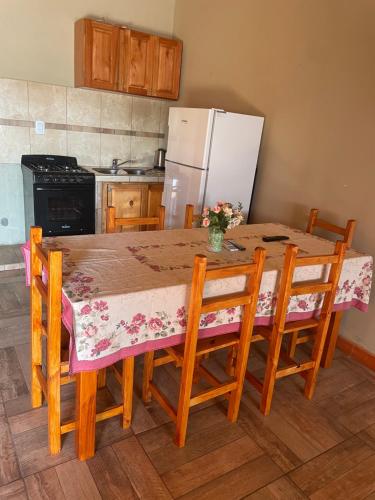 eine Küche mit einem Tisch mit Stühlen und einem Kühlschrank in der Unterkunft Cabañas “La India” in Jardín América