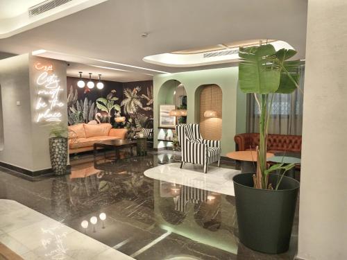 ein Wohnzimmer mit einer Pflanze in einem großen Topf in der Unterkunft Citi Loft Furnished Apartments in Beirut