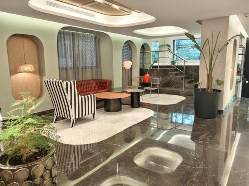 eine Lobby mit einem Sofa, einem Tisch und Stühlen in der Unterkunft Citi Loft Furnished Apartments in Beirut