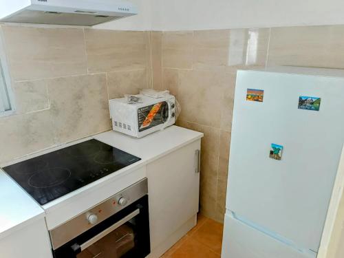 a kitchen with a white refrigerator and a microwave at Playa Sant Antonio muy cercana in Cullera