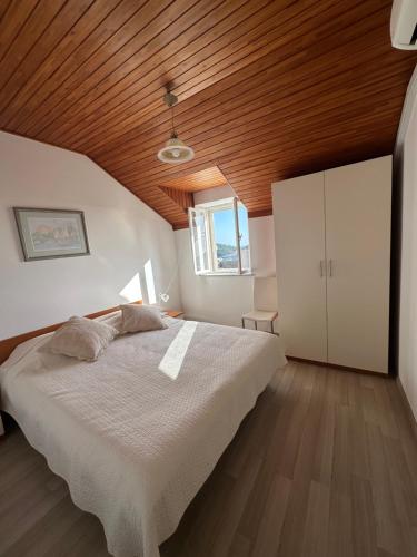 ein Schlafzimmer mit einem großen Bett und einer Holzdecke in der Unterkunft Guest House Katić in Dubrovnik