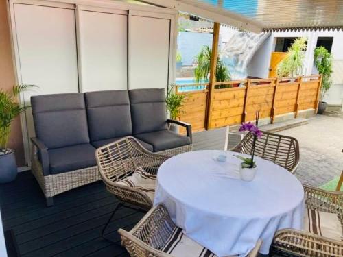 a patio with a table and chairs and a couch at Chez Arlette in Saint-Louis