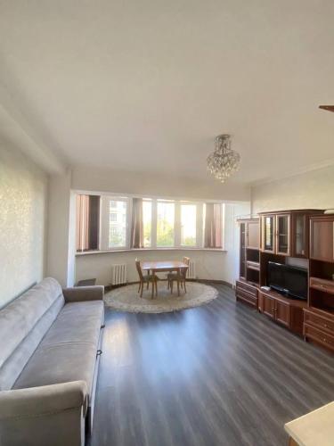 uma sala de estar com um sofá e uma mesa em Уютный уголок в центре города em Bishkek