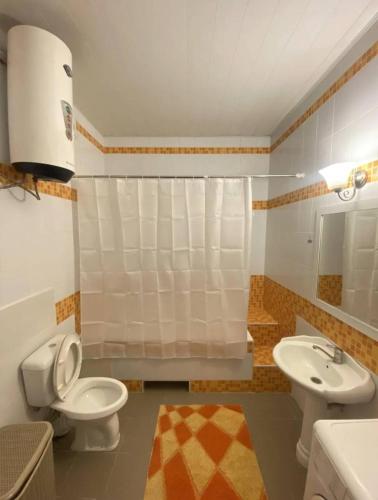 uma casa de banho com um WC e um lavatório em Уютный уголок в центре города em Bishkek