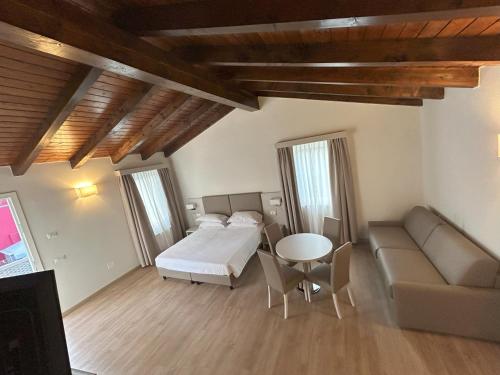 a bedroom with a bed and a couch and a table at La Casetta in Sarmeola