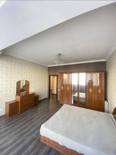 um quarto grande com uma cama grande e uma cómoda em Уютный уголок в центре города em Bishkek