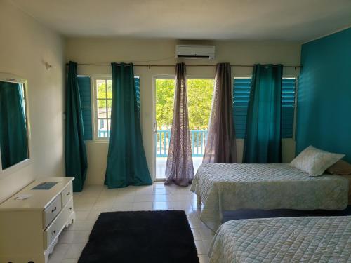 een slaapkamer met 2 bedden en een raam bij The Resort at West End in Negril