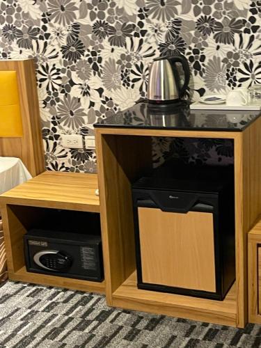 a kitchen with a microwave and a coffee pot on a counter at Yiting Hotel in Kaohsiung