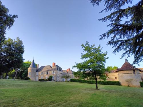 un château avec un arbre au milieu d'un champ dans l'établissement COTTAGE, à La Chapelle-Bâton
