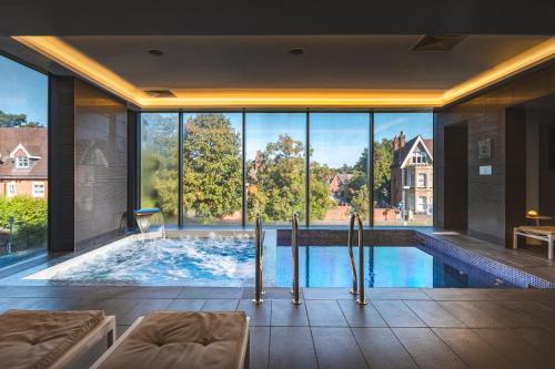 a large indoor swimming pool with a large window at Harbour Hotel & Spa Guildford in Guildford