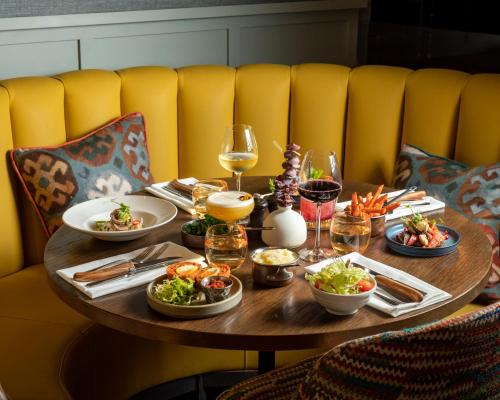 a table with plates of food and glasses of wine at Harbour Hotel & Spa Guildford in Guildford