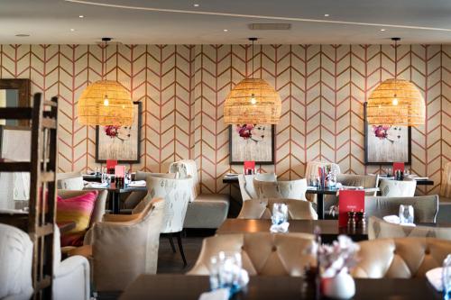 a restaurant with white chairs and tables in a room at Harbour Hotel & Spa Guildford in Guildford