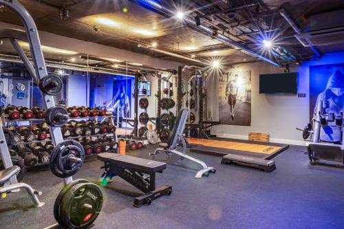 a gym with several tread machines and weights at Harbour Hotel & Spa Guildford in Guildford