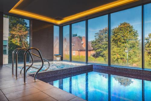 a swimming pool with two chairs in a house at Harbour Hotel & Spa Guildford in Guildford