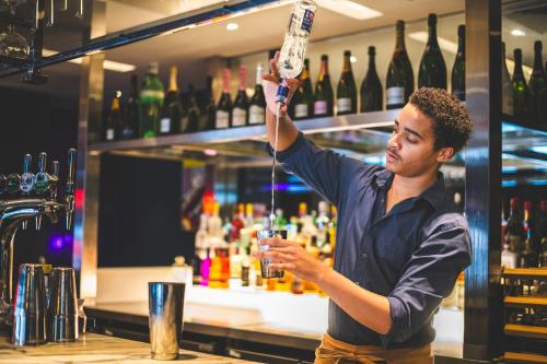 a man preparing a drink at a bar at Harbour Hotel & Spa Guildford in Guildford
