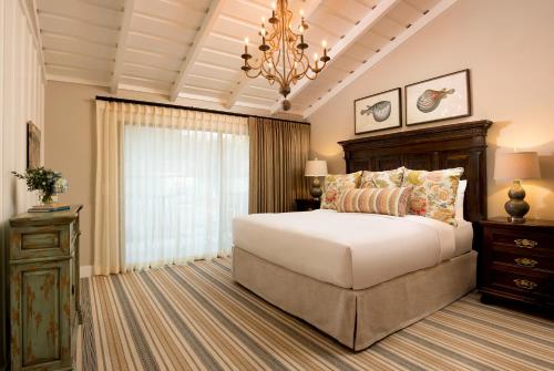 a bedroom with a large bed and a chandelier at The Ranch at Laguna Beach in Laguna Beach