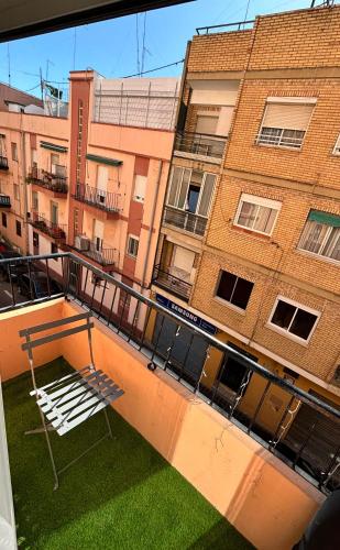 un banco blanco en un balcón frente a un edificio en Cute and Cosy habitación privada con balcón en Valencia