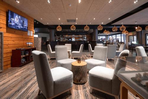um restaurante com cadeiras e um bar com televisão em Lapland Hotels Ylläskaltio em Äkäslompolo