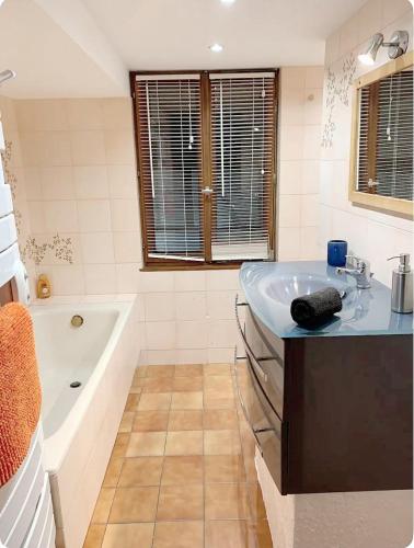 une salle de bain avec un lavabo et une baignoire dans l'établissement Gîte de Juliana 6 personnes, à Sundhouse