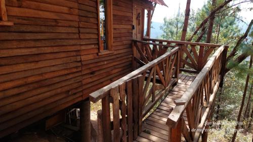 a wooden staircase leading to the side of a cabin at Cabaña en el Bosque de San José del Pacífico 4 in San Mateo Río Hondo