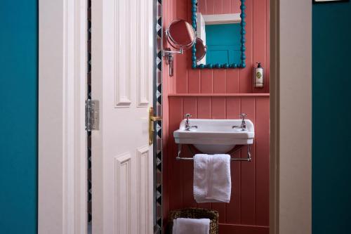 a bathroom with a sink and a mirror at The White Horse - A Heartwood Inn in Dorking