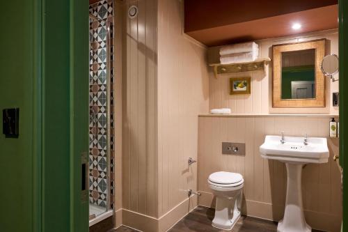 a bathroom with a white toilet and a sink at The White Horse - A Heartwood Inn in Dorking