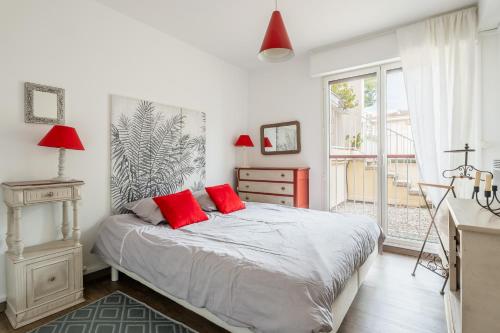une chambre avec un lit avec deux oreillers rouges dans l'établissement Le Kallisté par Dodo à Cassis, à Cassis