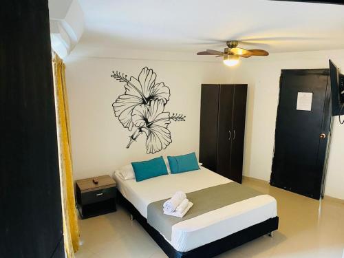 sypialnia z łóżkiem z rysunkiem kwiatu na ścianie w obiekcie HOTEL TREE HOUSE MEDELLiN w mieście Medellín