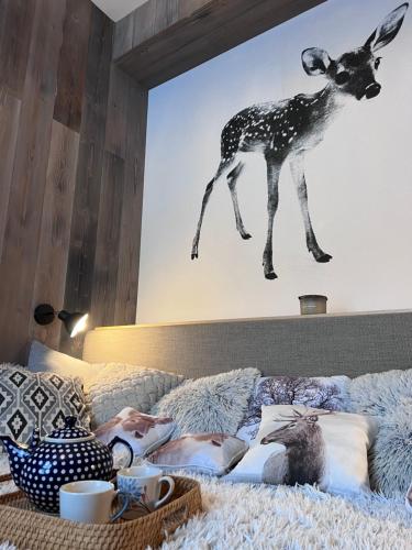 a bed with a picture of a deer on the wall at SKI apartment - Rezidence LYSÁ HORA in Rokytnice nad Jizerou