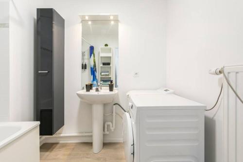 a white bathroom with a sink and a mirror at Appartement neuf Disney-Paris in Bonneuil-sur-Marne
