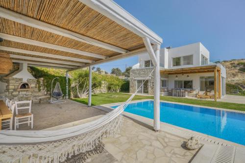 a hammock on the patio of a house with a swimming pool at Villa Kalimera swimming pool Pitsidia Matala Komos in Pitsidia