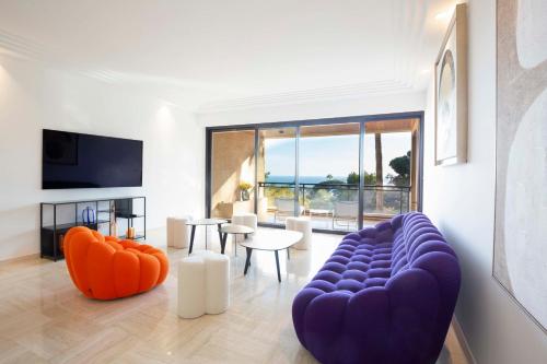 - un salon avec un canapé bleu et des fauteuils orange dans l'établissement Exceptional Super-Cannes Glaïeuls with sea view swimming pools jacuzzi, à Vallauris
