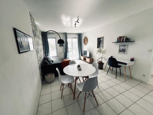 sala de estar con mesa blanca y sillas en Cocon tout confort à 5 min de gare Saint-Jean, en Bègles