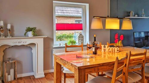 a dining room with a table and a fireplace at Hüs bi Söl - Haus bei Sylt in Uphusum