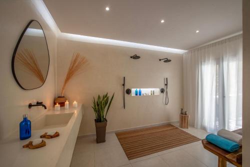 Un baño con bañera, lavabo y espejo. en Bohemian Blue, en Hersonissos