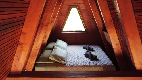 an attic room with a bed with a window at A-frame off the grid in Khalikerí