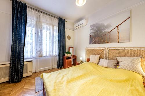 ブダペストにあるBalzac Apartmentのベッドルーム1室(黄色いベッド1台、窓付)
