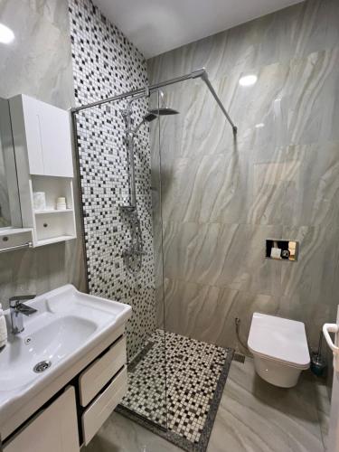 y baño con ducha, lavabo y aseo. en HOTEL SYLBICA en Kolgecaj