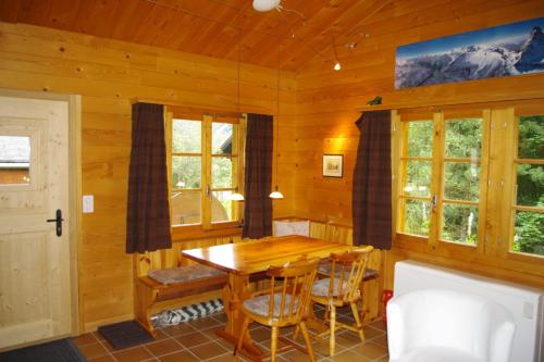 - une salle à manger avec une table et des chaises en bois dans l'établissement Le Bouvreuil Zinal, le VRAI petit chalet de vacances!, à Zinal