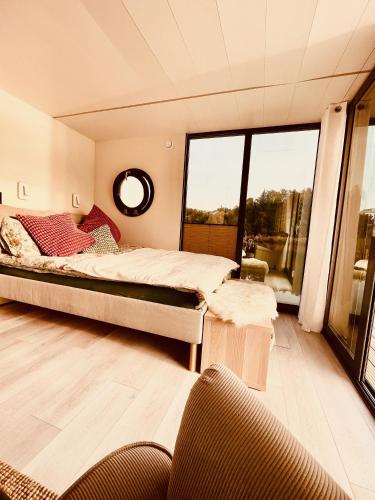 a bedroom with a bed and a large window at Hausboot Eisvogel in Kirchberg an der Raab