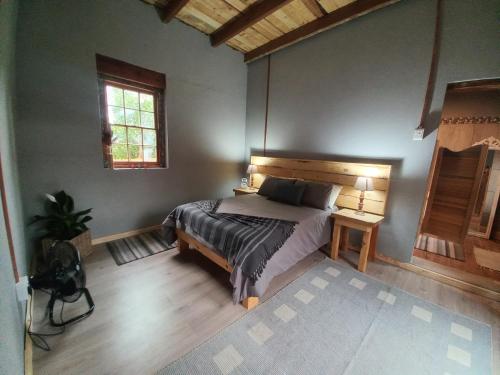 De RustにあるThe Cottageのベッドルーム1室(ベッド1台、テーブル、窓付)