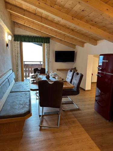a living room with a table and chairs and a television at Hundsidl in Mittersill