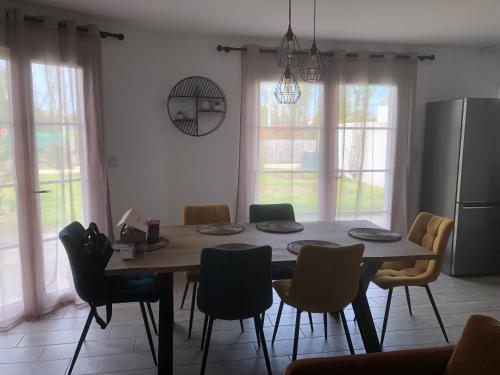 - une table à manger et des chaises dans la cuisine dans l'établissement La Rose Trémière, à Saint-Pierre-dʼOléron
