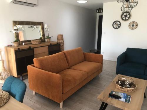 un salon avec un canapé et une table dans l'établissement La Rose Trémière, à Saint-Pierre-dʼOléron