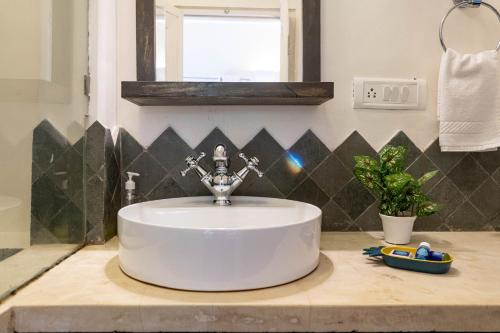 a bathroom with a white sink and a mirror at Villa Olive goa ( OV private pool villas ) in Mapusa