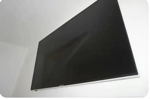 a flat screen tv hanging on a white wall at Elvi Apartment 1 in Rachonio