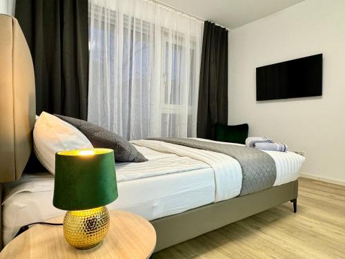 a bedroom with a bed and a table with a lamp at Modernes Apartment nahe des Stadtzentrums in Hannover