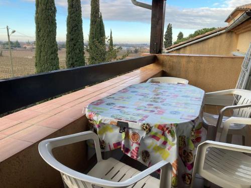 a table and chairs sitting on a balcony at Joli appartement et terrasse vue sur les dentelles in Sablet