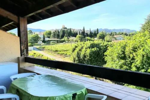 a table and chairs on a balcony with a view at Joli appartement et terrasse vue sur les dentelles in Sablet